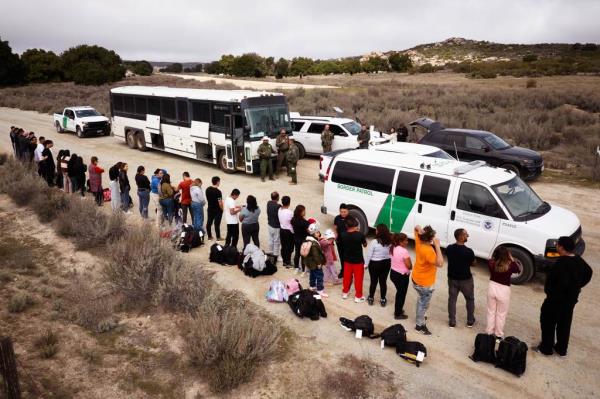 Migrants are processed by U.S. Customs and Border Protection officers after they crossed ithe U.S.-Mexico border.