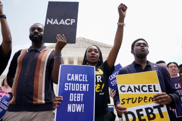 Students protesting a<em></em>bout student loan debt outside the Supreme Court, with signs