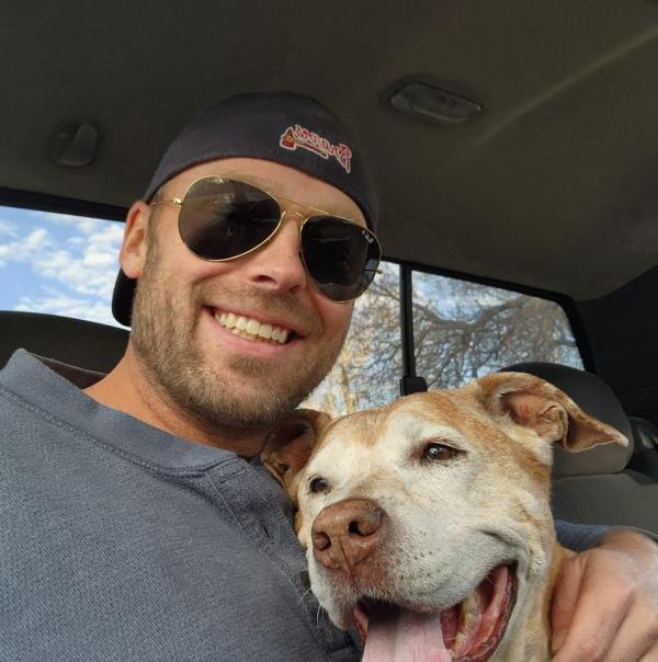 Michael O'Neal smiles with a dog 