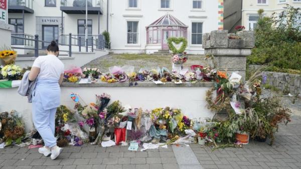 A person looking at flowers outside Sinead O'Connor's former home in Bray, Co Wicklow