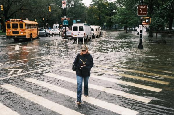 People walk through flooded sidewalks by Prospect Park South and Ocean Parkway in the aftermath from tropical storm Ophelia.