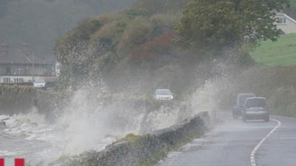 Cars pass waves crashing over a wall into the road in Youghal, Co Cork. Weather warnings will come into force as the UK and Ireland brace for the arrival of Storm Agnes, which will bring damaging winds and big stormy seas. Agnes, the first named storm of the season, will affect western regions of the UK and Ireland, with the most powerful winds expected on the Irish Sea coasts. Picture date: Wednesday September 27, 2023. PA Photo. Photo credit should read: Niall Carson/PA Wire