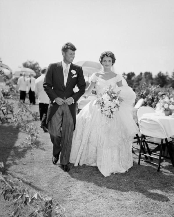 John F. Kennedy walks alo<em></em>ngside his bride Jacqueline at their outdoor wedding reception in Newport, Rhode Island in 1953.