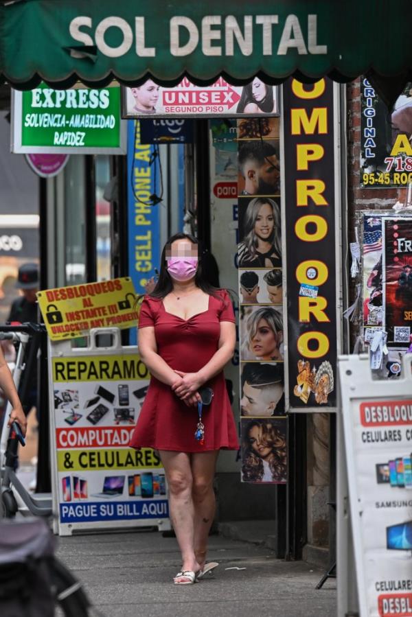 A woman outside a suspected sex shop on Roosevelt Ave. 230725, Roosevelt Ave.