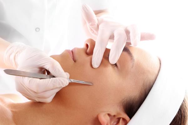 A Caucasian woman undergoing surgery with a scalpel.