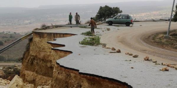 People stand in a damaged road as a powerful storm and heavy rainfall flooded hit Shahhat city, Libya, September 11, 2023. REUTERS/Omar Jarhman NO RESALES. NO ARCHIVES. REFILE - REMOVING WATERMARK