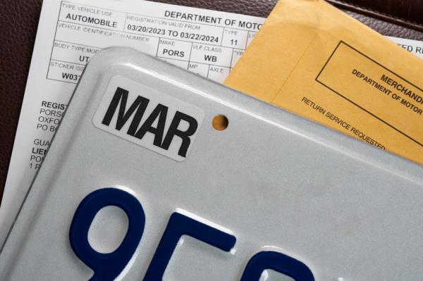 License plate registration docu<em></em>ments and envelope on leather surface. DMV USA. 