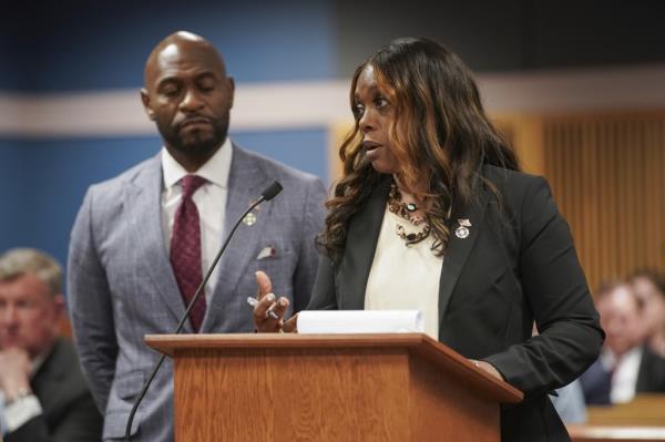 Nathan Wade looks on in a grey suit and maroon tie as Daysha Young, in a black jacket, speaks at a hearing for former President Do<em></em>nald Trump