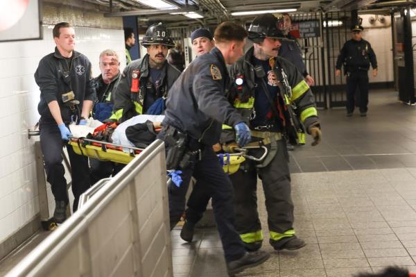 FDNY crews carry stretcher holding critically injured woman.