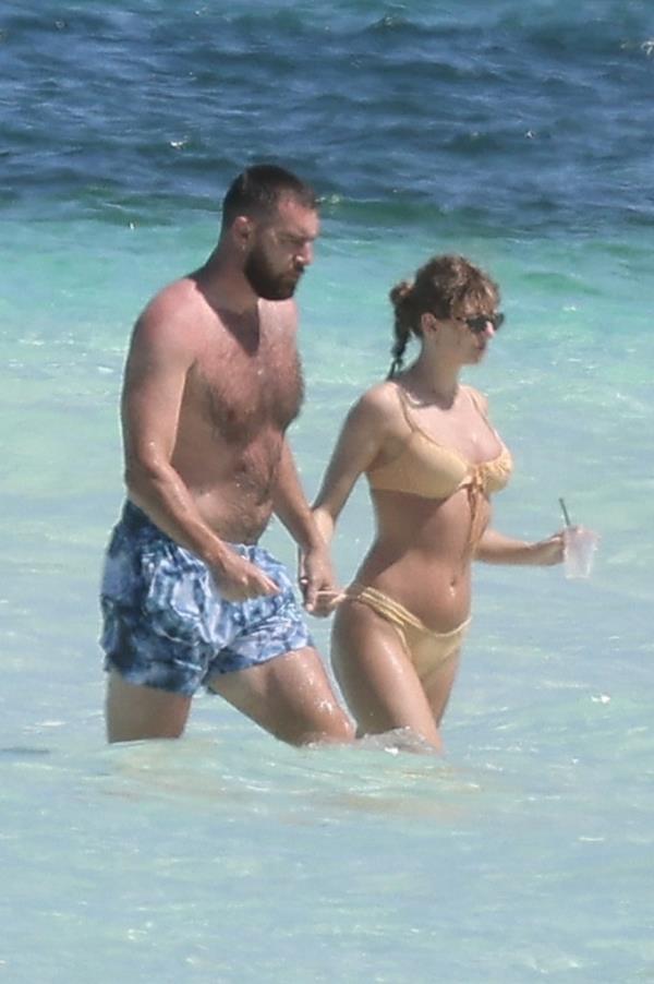 Travis Kelce and Taylor Swift take in the sure while on vacation on Harbour Island, Bahamas, on March 21, 2024.