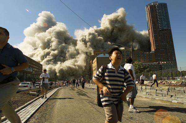 People run away as the second tower of World Trade Center crumbles down after a plane hit the building