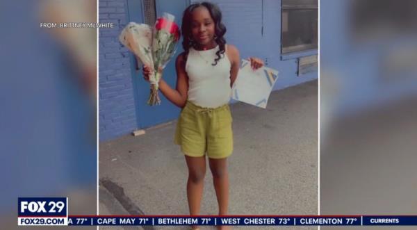 Girl holding flowers and a graduation certificate, celebrating her recent middle school graduation