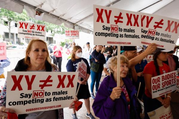 Demo<em></em>nstrators holding signs at the 'Our Bodies, Our Sports' rally in Washington DC for the 50th anniversary of Title IX