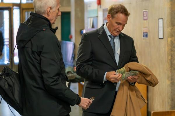 Michael Spillane thumbs through a wad of bills next to his attorney after his court appearance Monday.