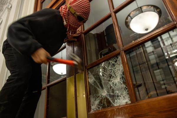 A protester breaking a window at Columbia's Hamilton Hall on April 30, 2024.