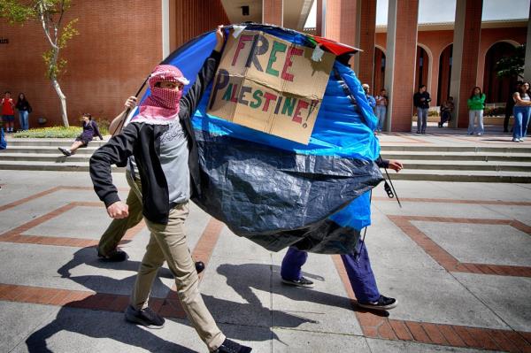 University of Southern California protesters carrying a tent near an encampment on campus on April 24, 2024.