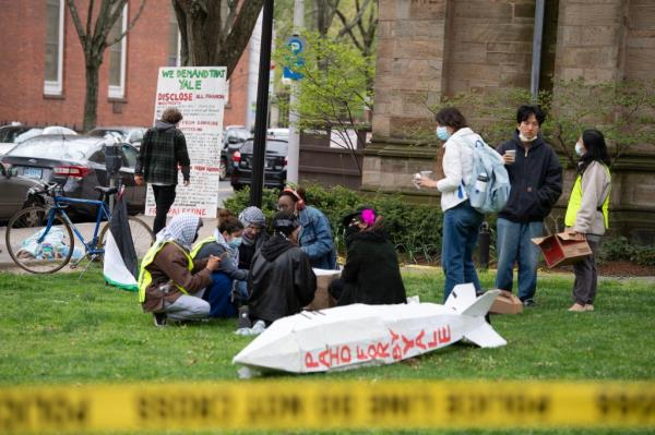 Yale protesters sitting on a lawn after being forced to leave their encampment by officials on April 30, 2024.