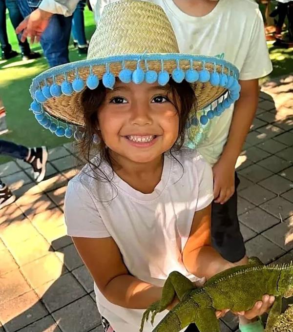 Yaretzi Noemi Biorato, 5, is pictured in a sombrero holding a lizard.