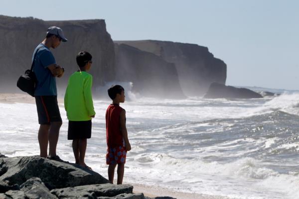 Eugene Chen (left) watches the heavy surf roll o<em></em>nto Martin's Beach with his sons Silas, 9, and Oliver 7, in Half Moon Bay, Calif. in 2014.