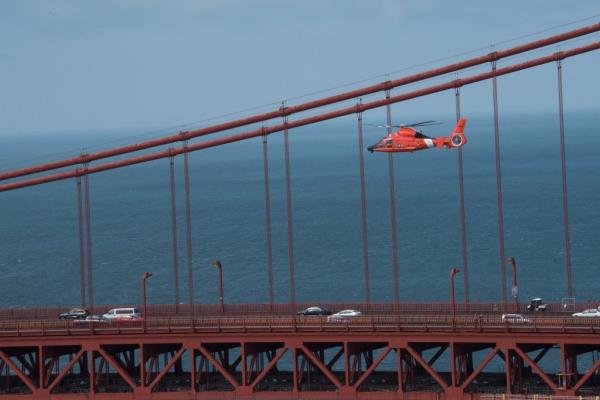 A US Coast Guard helicopter is pictured flying over the Golden Gate Bridge during the search.