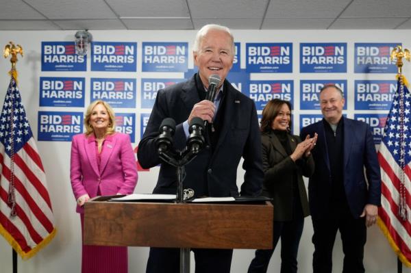 Joe Biden with Jill Biden, Kamala Harris and Doug Emhoff standing at a podium during the opening of Biden for President campaign office.