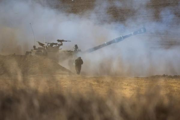 An Israeli army self-propelled howitzer fires rounds towards the Gaza Strip in southern Israel on October 13, 2023. Palestinians carried belo<em></em>ngings through the rubble-strewn streets of Gaza City October 13 in search of refuge as Israel's army warned residents to flee immediately before an expected ground offensive in retaliation against Hamas for the deadliest attack in Israeli history. (Photo by JACK GUEZ / AFP) (Photo by JACK GUEZ/AFP via Getty Images)