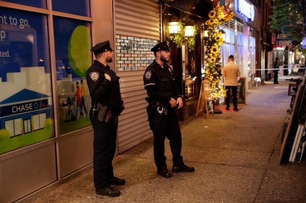 NYPD officers stand near the scene wher<em></em>e a woman was stabbed at a Thai Grocery store in Manhattan on Tuesday night.