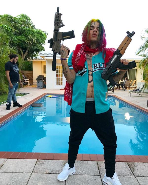 Tekashi 6ix9ine with colorful hair and headband holding stacks of mo<em></em>ney after being released from prison in 2020