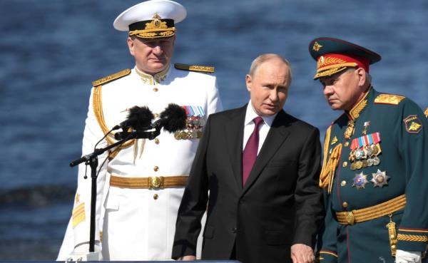 Russian President Vladimir Putin, center, reviews the parade of naval vessels accompanied by Russian Defence Minister Sergei Shoigu, right, and Naval Commander Nikolai Yevmenov, left, o<em></em>nboard the naval cutter Raptor on the Neva River, July 30, 2023 in St. Petersburg, Russia. 