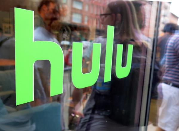 Hulu logo displayed on a window at Milk Studios in New York, with replica of Seinfeld set in the background