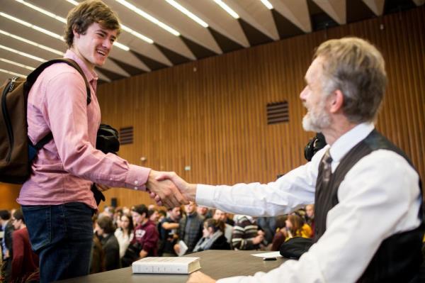 Jordan Peterson shaking hands with a young man