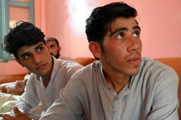 Niaz Muhammad (R) and Attaullah Shah, survivors of the cable car accident speak during an interview with AFP at a school in the Pashto village of mountainous Khyber Pakhtunkhwa province on August 23, 2023, a day after being rescued from a chairlift that plunged into a ravine. Military helicopters and ziplining commandos rescued eight people, including six schoolboys, who were trapped for hours on August 22, in a stricken cable car high above a remote Pakistani valley. (Photo by Farooq NAEEM / AFP) (Photo by FAROOQ NAEEM/AFP via Getty Images)