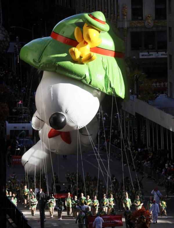 A giant Snoopy balloon flies through the streets of NYC during the parade.