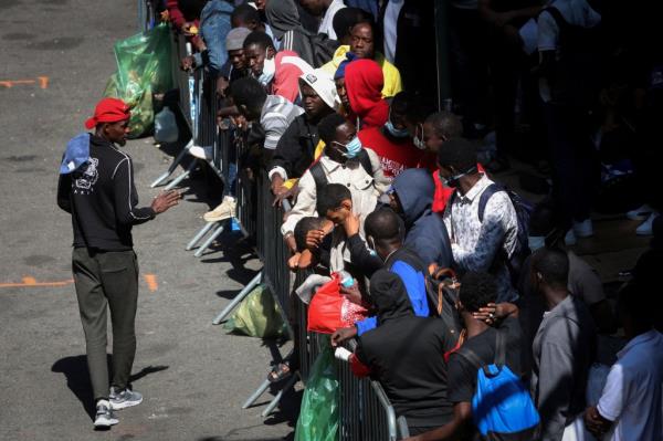 ecently arrived migrants to New York City wait on the sidewalk outside the Roosevelt Hotel