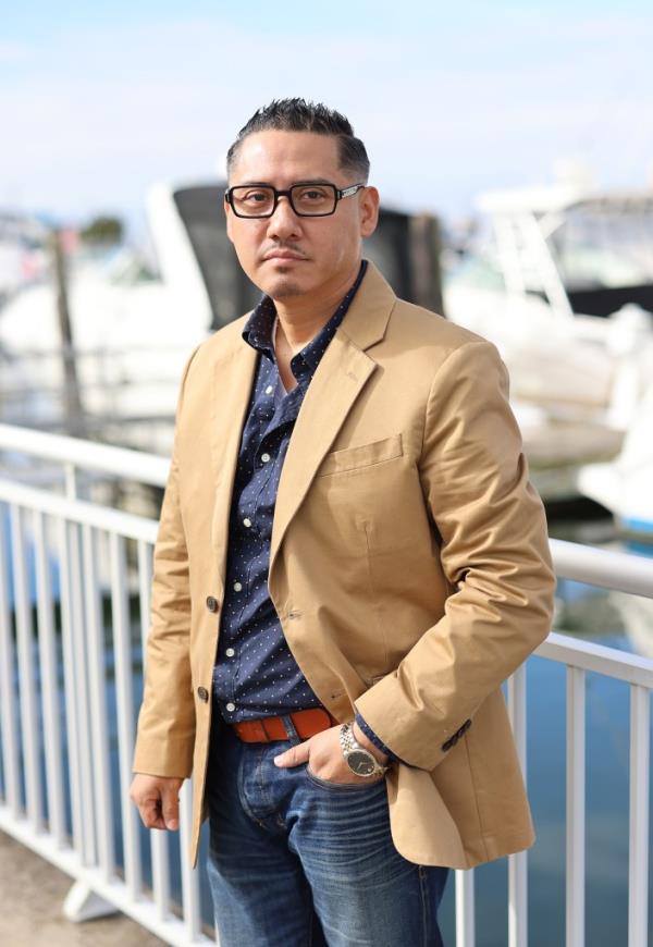 Hidalgo poses for a portrait in Wantagh in a brown jacket.