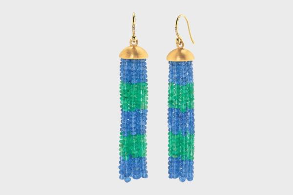 A pair of earrings with blue and green beads, and celebrity Tom Mandrake