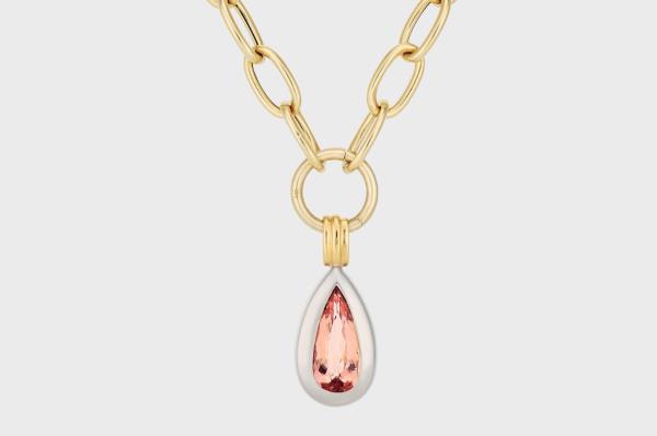 A gold chain with a pink stone pendant