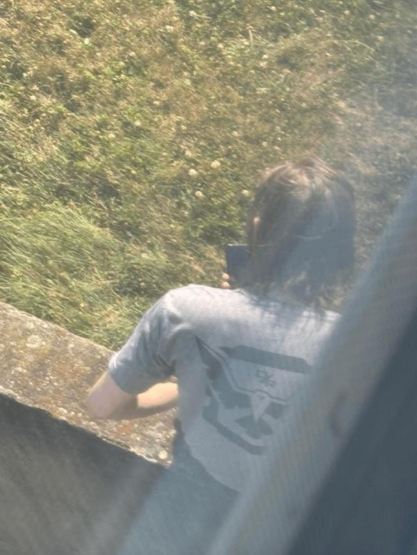 Thomas Matthew Crooks can be seen perched on a wall in a grassy area of the Butler Farm Show Grounds in Butler, Pa., on July 13 as he waited for Trump, 78, to take the stage.