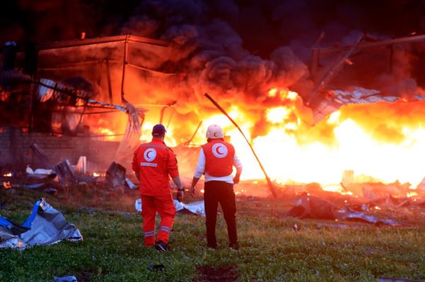 Civil defence workers check a burning warehouse, attacked by Israeli strikes, at an industrial district, in the southern coastal town of Ghazieh, Lebanon, Monday, Feb. 19.