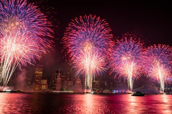 Colorful fireworks erupt over the East River just south of Brooklyn. 