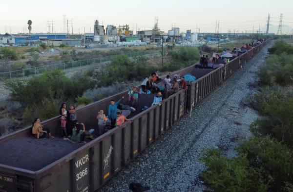 Asylum seekers heading to the US travel on a train after thousands of migrants crossed into the United States in recent days, in El Carmen, Mexico.