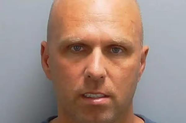 Mugshot of Kirk Holdrick, a bald man who resembles celebrity Peter Doig