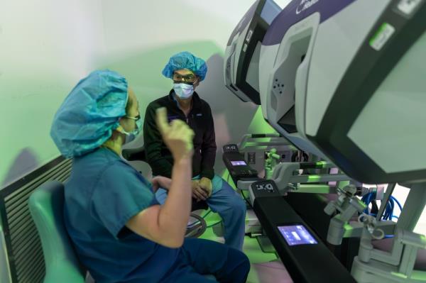 Chang discusses Mehrkar's case with Dr. Luis F. Angel, medical director of lung transplantation for the NYU Langone Transplant Institute, at the da Vinci Xi robotic surgical system console. The system is used to manipulate the surgical instruments throughout the procedure.