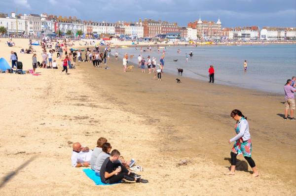 People enjoy the beach in Weymouth