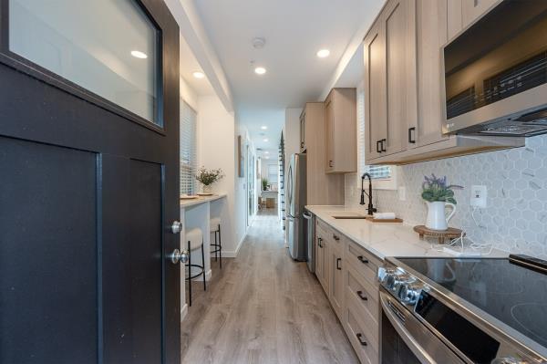 The sleek kitchen has stainless steel appliances and a custom dining bar.