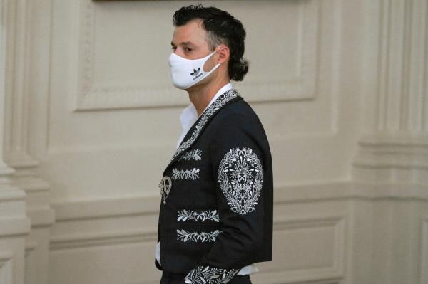 Los Angeles Dodgers relief pitcher Joe Kelly wears a Mariachi jacket and a mask while attending an event at the White House.