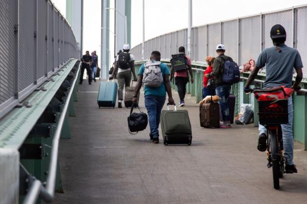 Migrants crossing the Ward Island Bridge after leaving a shelter on Randalls Island on Aug. 14, 2024.