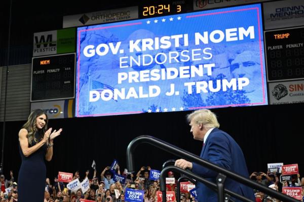 Gov. Kristi Noem welcomes former US president and 2024 Republican Presidential hopeful Do<em></em>nald Trump to the stage during the South Dakota Republican Party's Mo<em></em>numental Leaders rally in Rapid City, South Dakota, September 8, 2023.