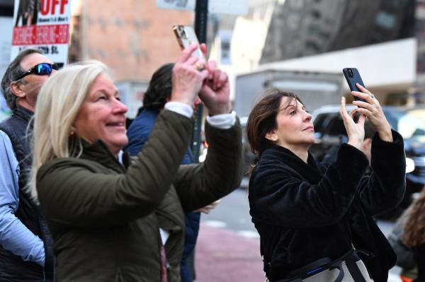 Shoppers take photos outside of the Louis Vuitton store on Fifth Avenue on Friday.