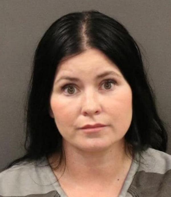 Mug shot of woman with Black hair.